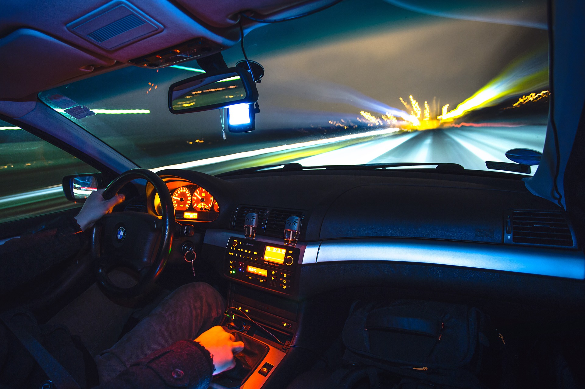 A passenger riding in a car with fast bright lights on the road