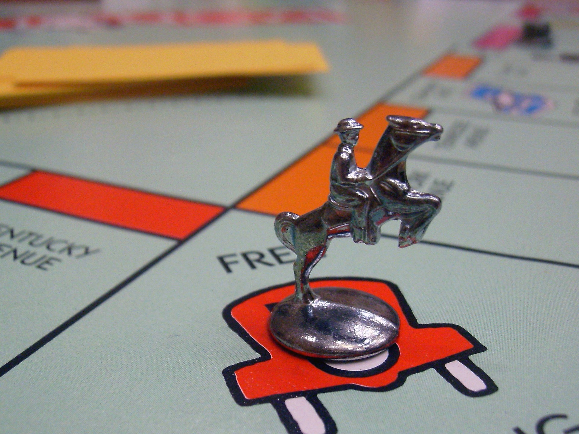 The cowboy riding a horse Monopoly piece on a Monopoly board