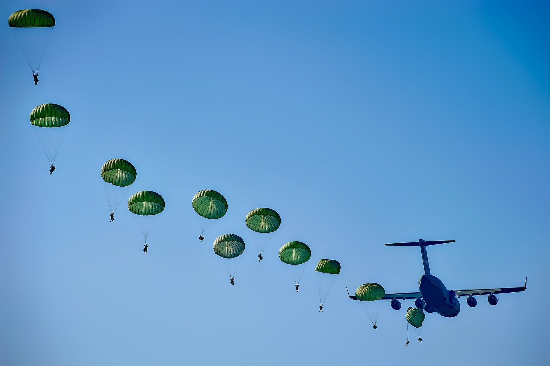A group of militray paratroopers jumping from a plane