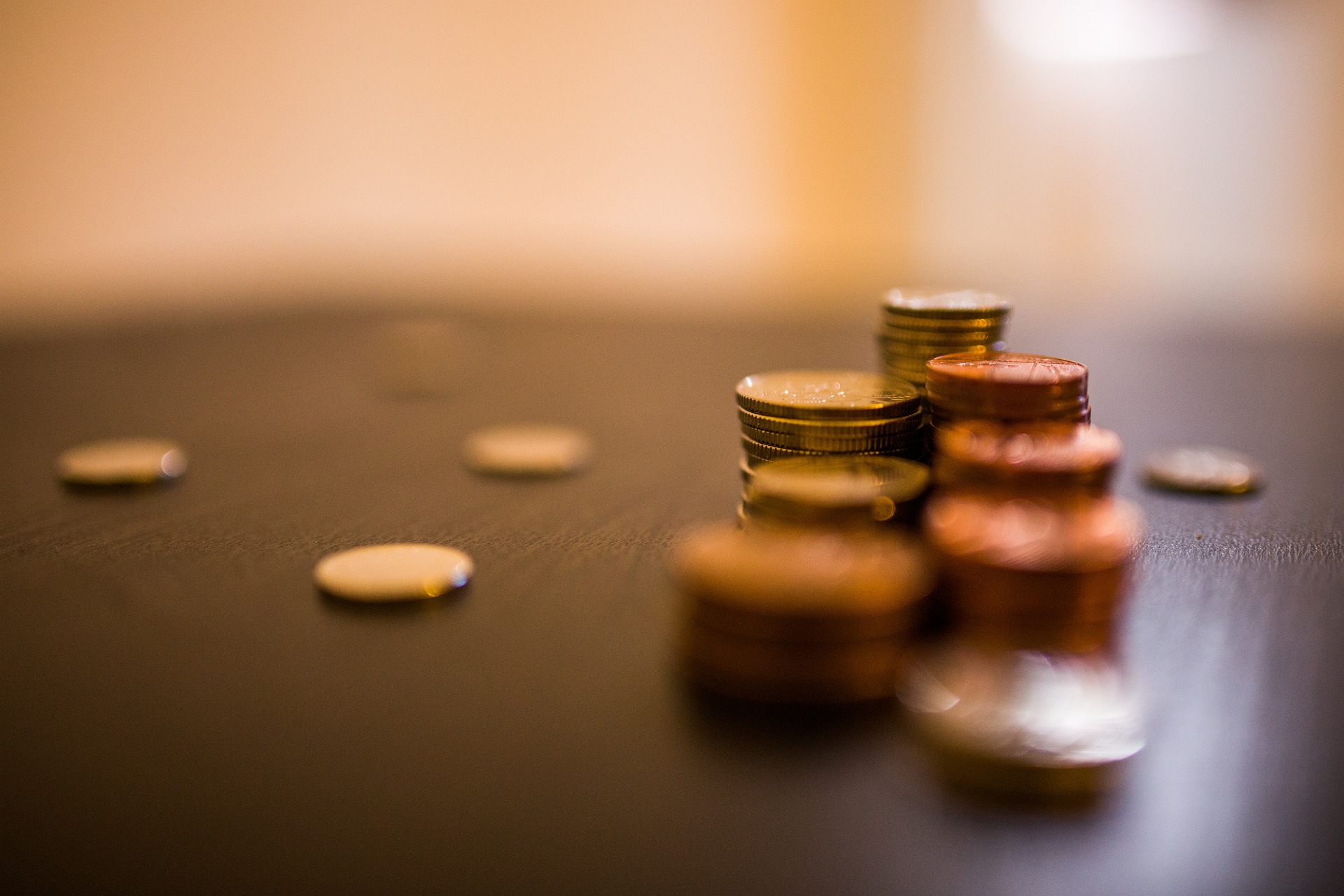A pile of coins on a table top.