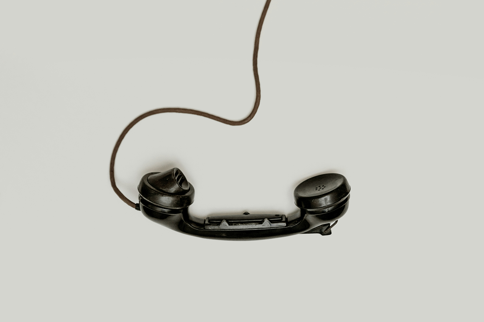 A black phone with a black phone cord.